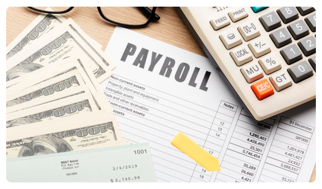 Payroll document beside cash, a checkbook, and a calculator